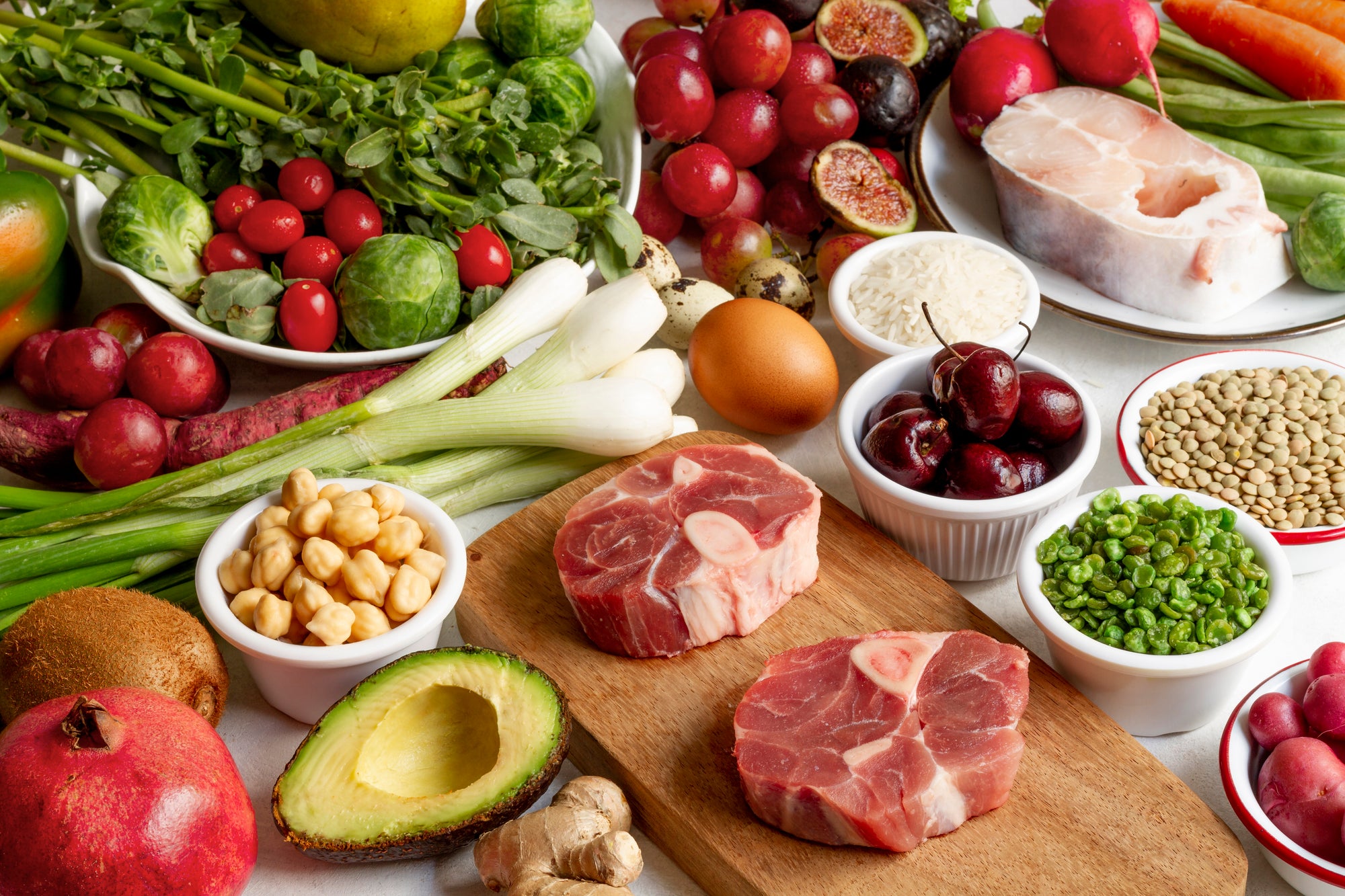 Assorted fresh fruits, vegetables, and meats on a table.