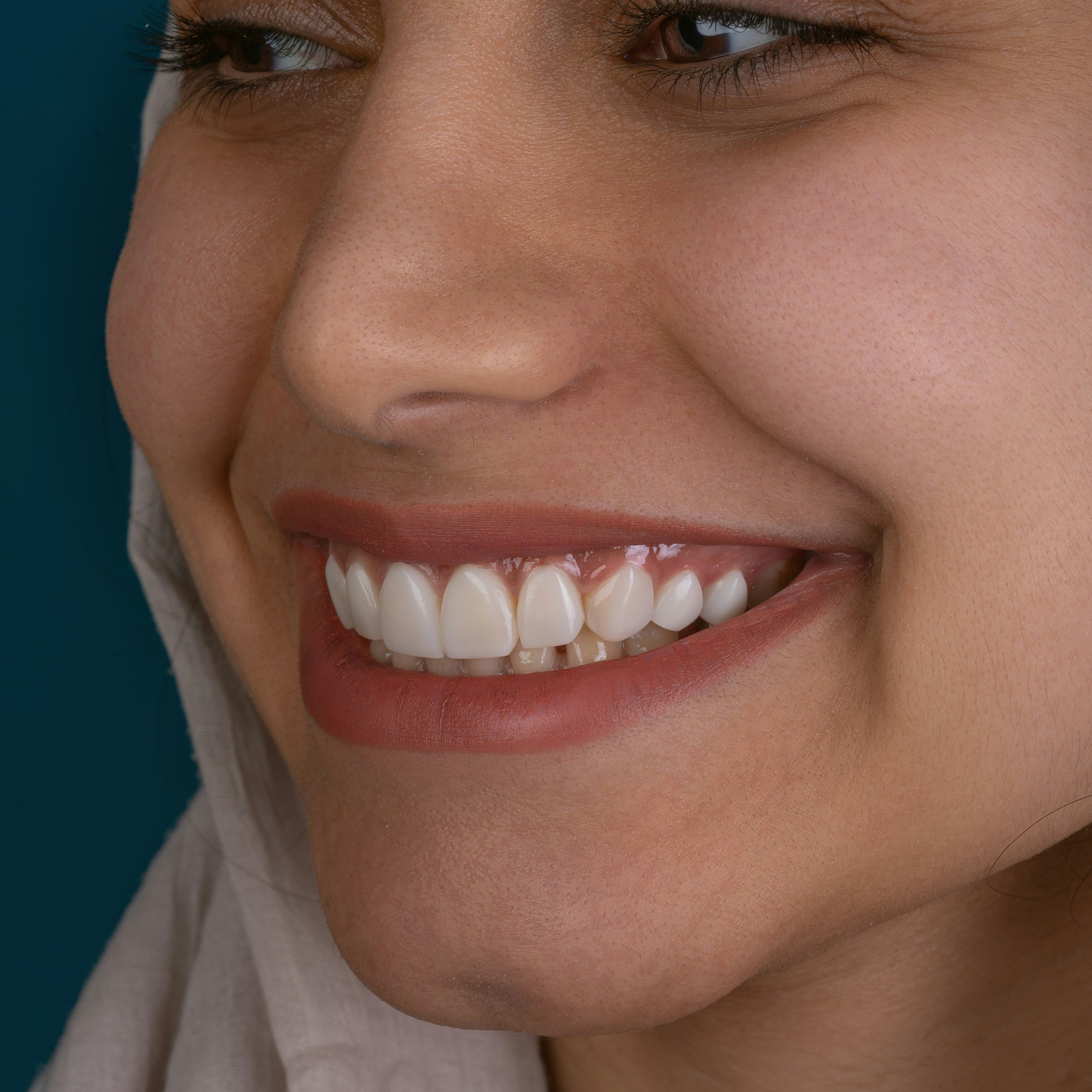 Close-up of a woman smiling with a blue background